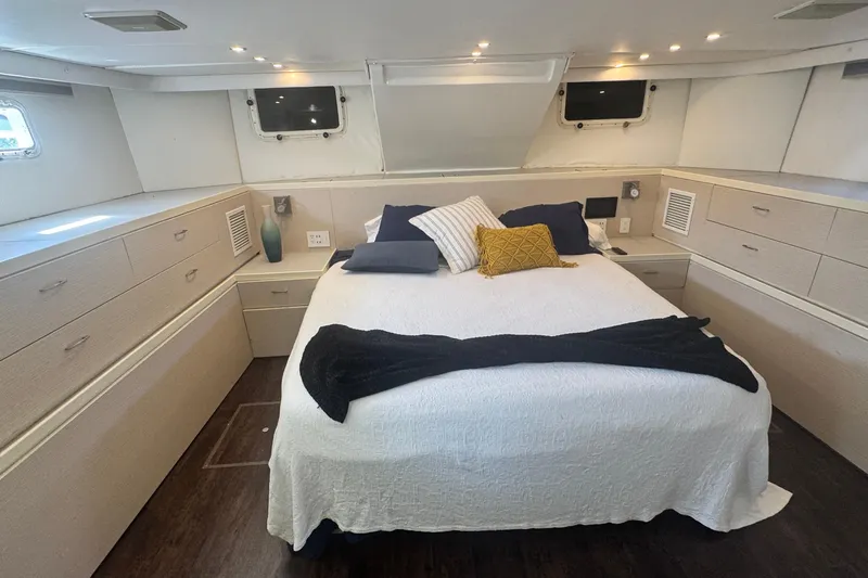 Music Yacht Photos Pics Luxurious bedroom interior of 1989 Hatteras 65 Motor Yacht with elegant bedding and ample storage.