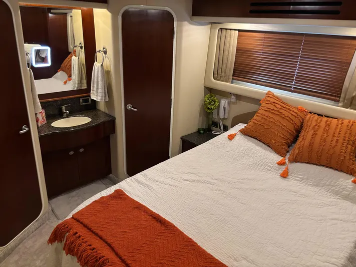 Tre Bella Yacht Photos Pics Luxurious 2005 Sea Ray 390 Motor Yacht bedroom with orange accents and ensuite bathroom.