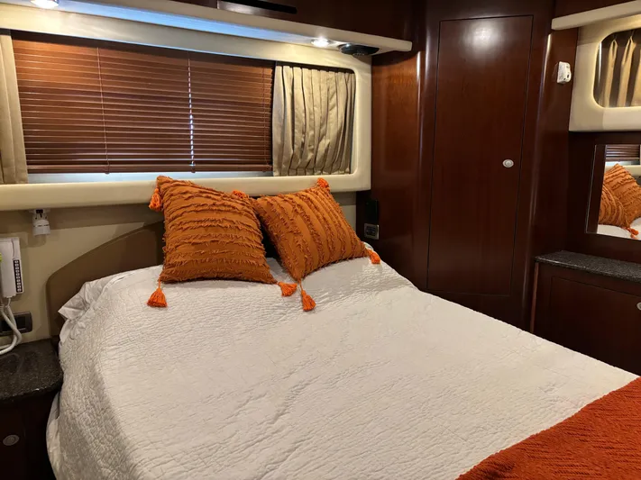 Tre Bella Yacht Photos Pics Luxurious 2005 Sea Ray 390 Motor Yacht bedroom with orange pillows and elegant wood finish.