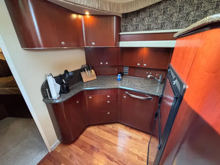 Tre Bella Yacht Photos Pics Luxurious kitchen interior of 2005 Sea Ray 390 Motor Yacht with wood cabinetry and granite countertops.