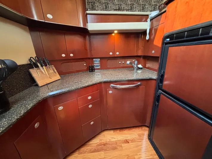Tre Bella Yacht Photos Pics Luxurious kitchen interior of 2005 Sea Ray 390 Motor Yacht with wooden cabinetry.