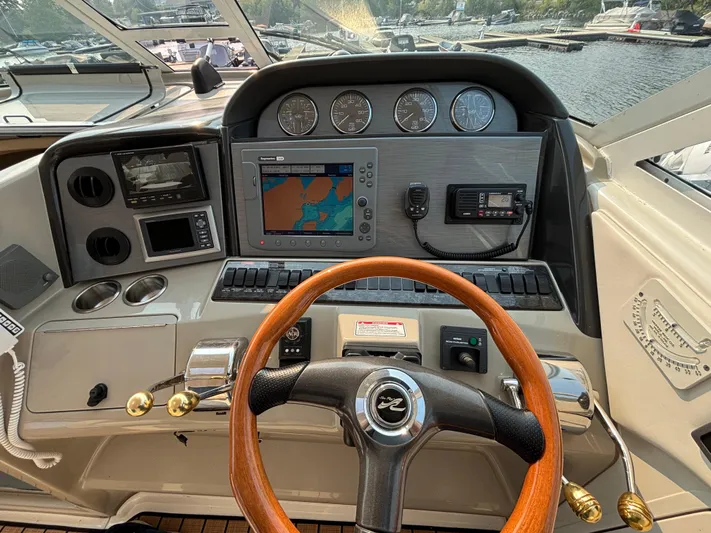 Tre Bella Yacht Photos Pics 2005 Sea Ray 390 Motor Yacht helm with navigation instruments and wooden steering wheel.