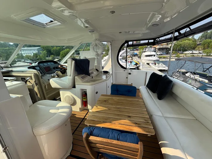 Tre Bella Yacht Photos Pics 2005 Sea Ray 390 Motor Yacht interior with helm, seating, and wooden table.