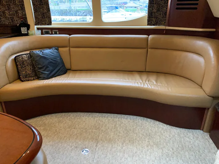 Tre Bella Yacht Photos Pics 2005 Sea Ray 390 Motor Yacht interior with curved leather seating and decorative pillows.