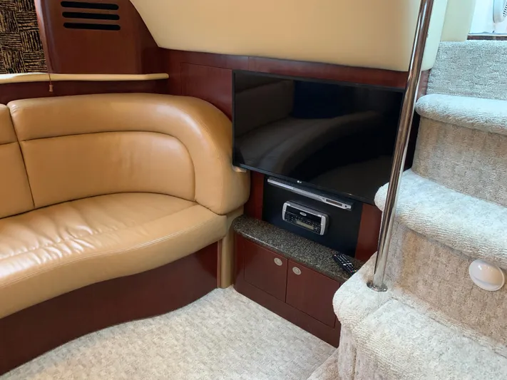 Tre Bella Yacht Photos Pics Interior of 2005 Sea Ray 390 Motor Yacht with TV, beige sofa, and carpeted stairs.