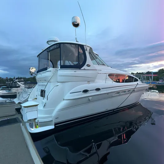 Tre Bella Yacht Photos Pics 2005 Sea Ray 390 Motor Yacht docked at sunset, reflecting on calm water.