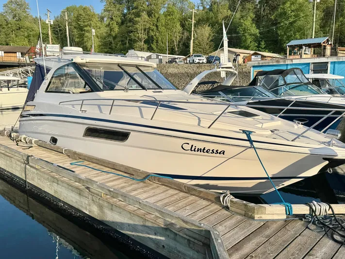 Clintessa Yacht Photos Pics 2012 Regal 35 Sport Coupe docked at a marina, surrounded by trees and boats.