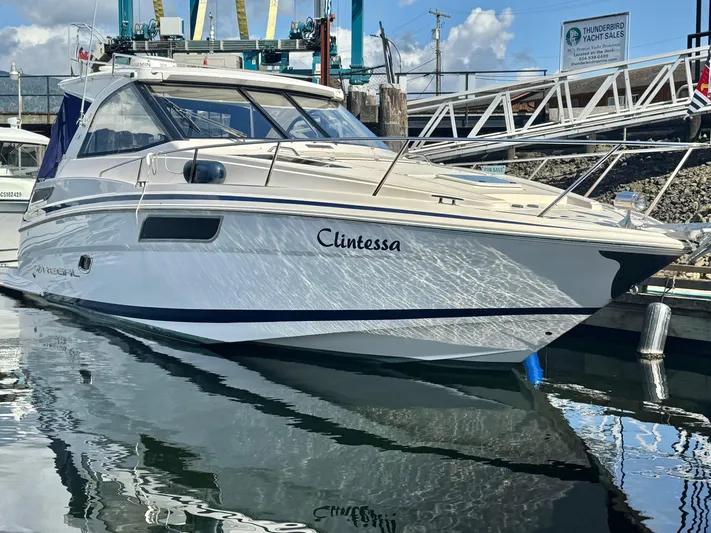 Clintessa Yacht Photos Pics 2012 Regal 35 Sport Coupe yacht docked at marina, reflecting on water.