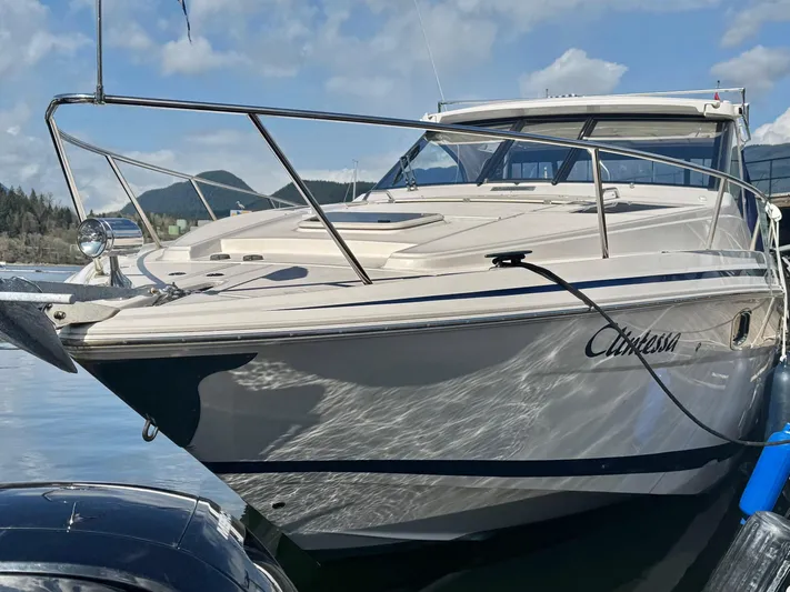 Clintessa Yacht Photos Pics 2012 Regal 35 Sport Coupe boat docked on a sunny day with mountains in the background.