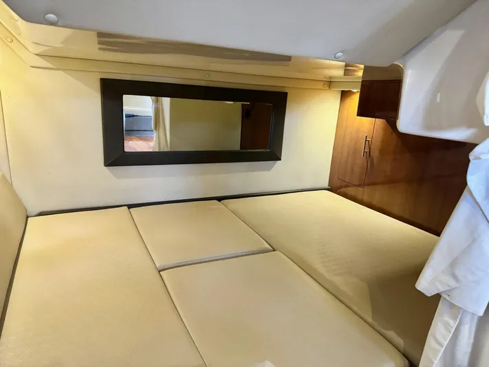 Clintessa Yacht Photos Pics 2012 Regal 35 Sport Coupe cabin interior with beige bedding and wall mirror.