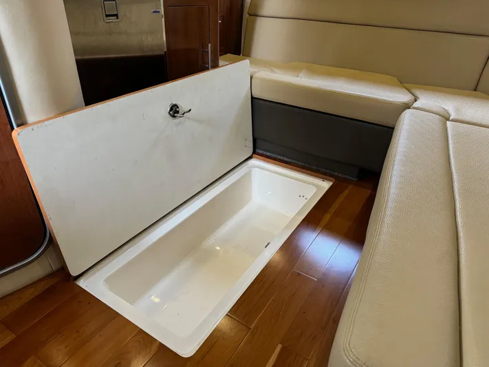 Clintessa Yacht Photos Pics 2012 Regal 35 Sport Coupe interior storage compartment with open lid on wooden floor.