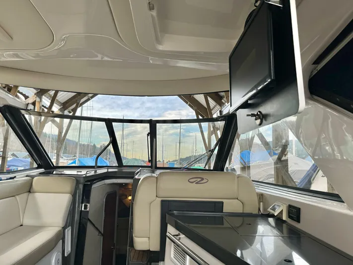 Clintessa Yacht Photos Pics Interior of a 2012 Regal 35 Sport Coupe yacht with seating and a mounted TV.