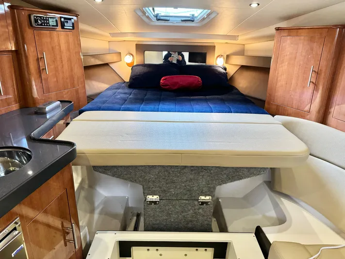 Clintessa Yacht Photos Pics Interior of 2012 Regal 35 Sport Coupe with cozy bed and wooden cabinetry.