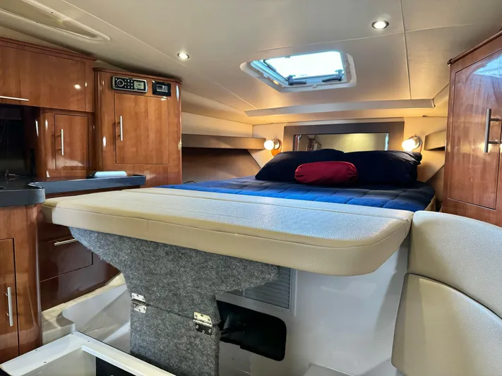 Clintessa Yacht Photos Pics Interior of 2012 Regal 35 Sport Coupe with cozy bed and wooden cabinetry.