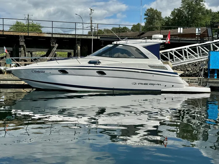 Clintessa Yacht Photos Pics 2012 Regal 35 Sport Coupe yacht docked in a marina, reflecting on calm water.
