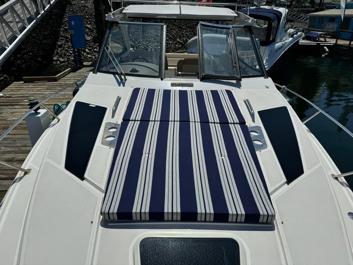 Clintessa Yacht Photos Pics 2012 Regal 35 Sport Coupe with striped sun pad on deck, docked at marina.