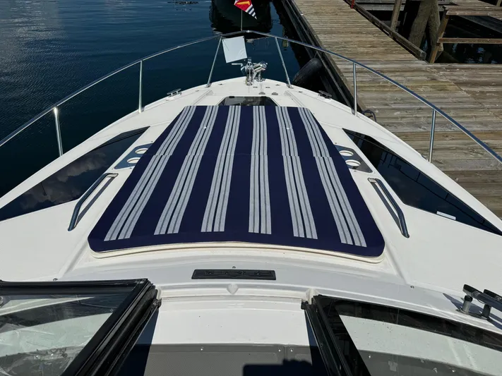 Clintessa Yacht Photos Pics 2012 Regal 35 Sport Coupe boat with striped deck pad, docked by wooden pier.