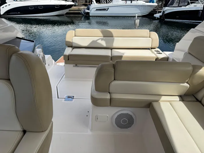 Clintessa Yacht Photos Pics 2012 Regal 35 Sport Coupe interior with beige seating, docked near other boats.