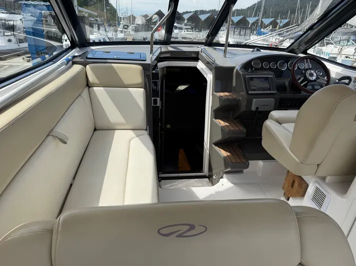 Clintessa Yacht Photos Pics Interior of 2012 Regal 35 Sport Coupe with beige seating and helm.