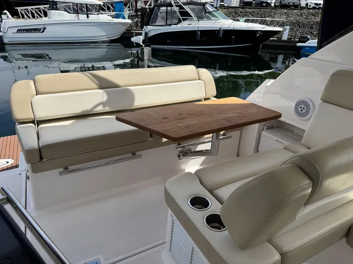 Clintessa Yacht Photos Pics 2012 Regal 35 Sport Coupe interior with beige seating and wooden table, docked at marina.