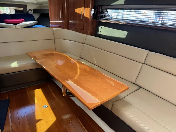 Clintessa Yacht Photos Pics Interior of 2012 Regal 35 Sport Coupe with beige seating and wooden table.