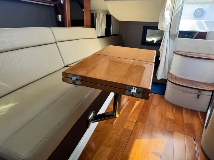 Clintessa Yacht Photos Pics Interior of 2012 Regal 35 Sport Coupe with wooden table and beige seating.