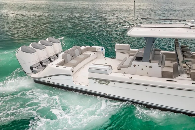  Yacht Photos Pics 2023 HCB 53 Sueños boat cruising on turquoise water, featuring multiple outboard engines.