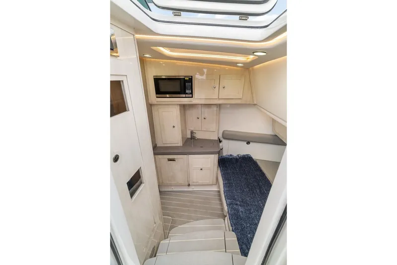  Yacht Photos Pics Interior of 2023 HCB 53 Sueños boat with kitchenette and seating area.