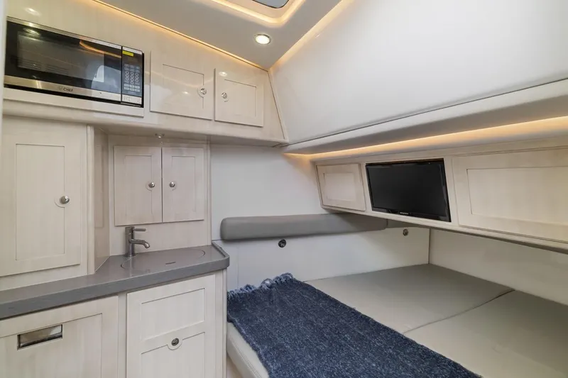  Yacht Photos Pics Luxurious interior of 2023 HCB 53 Sueños yacht with kitchenette and cozy sleeping area.