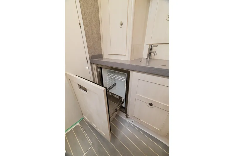  Yacht Photos Pics 2023 HCB 53 Sueños yacht interior with open cabinet and sink.