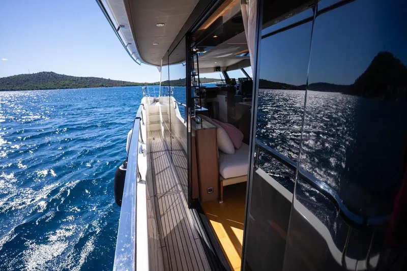 Leena Yacht Photos Pics Prestige X60 yacht cruising on blue waters, reflecting sunlight, 2023 model.