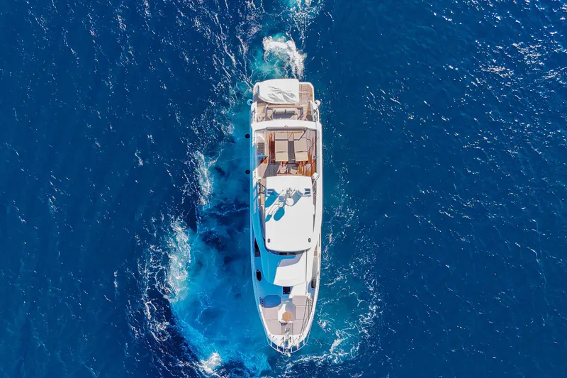 Leena Yacht Photos Pics Aerial view of 2023 Prestige X60 yacht cruising in deep blue ocean waters.