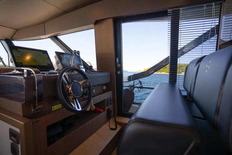 Leena Yacht Photos Pics Interior of 2023 Prestige X60 yacht with steering wheel and navigation screens.