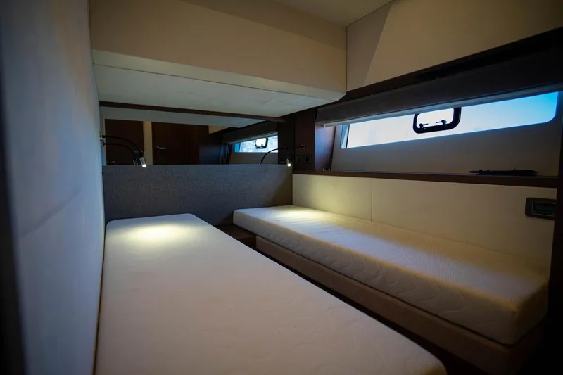 Leena Yacht Photos Pics Interior of 2023 Prestige X60 yacht cabin with twin beds and ambient lighting.