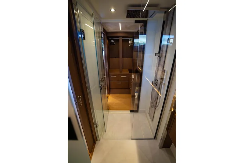 Leena Yacht Photos Pics Luxurious interior of 2023 Prestige X60 yacht featuring sleek glass shower and modern cabinetry.