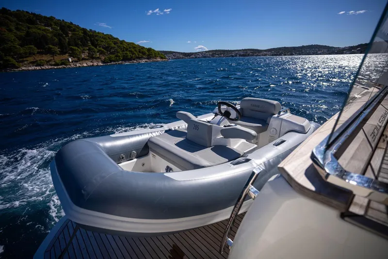 Leena Yacht Photos Pics Luxury 2023 Prestige X60 yacht on blue ocean, sunny day, scenic coastline.