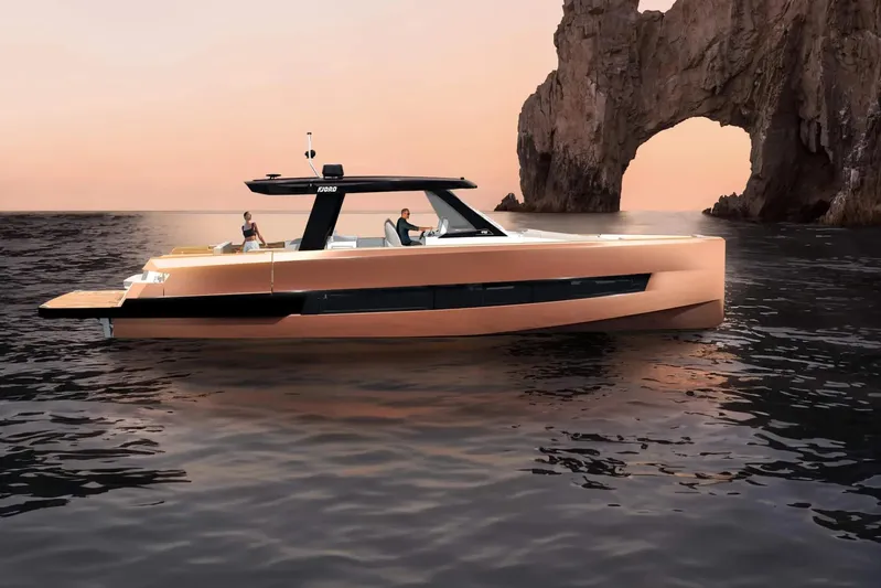  Yacht Photos Pics 2026 Fjord 490 OPEN yacht cruising at sunset near rocky arch formation.