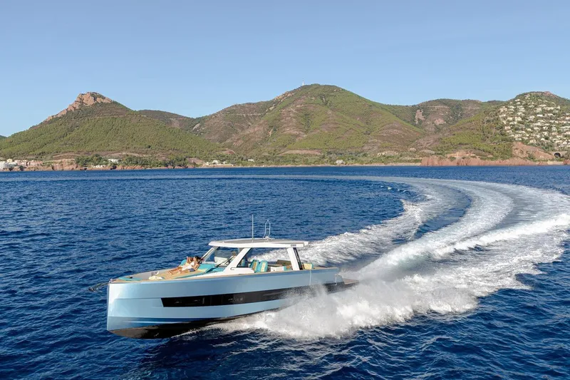  Yacht Photos Pics 2026 Fjord 490 OPEN yacht cruising on blue ocean with scenic mountain backdrop.