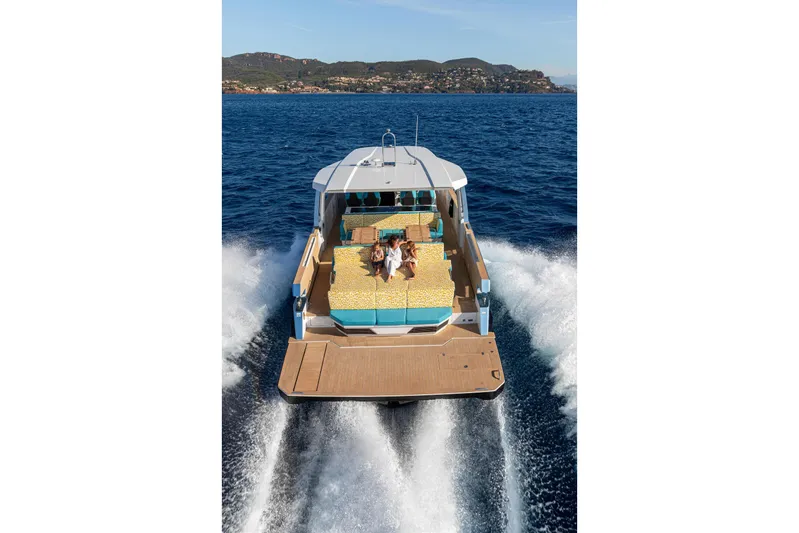  Yacht Photos Pics 2026 Fjord 490 OPEN cruising on ocean, featuring spacious deck and sunbathing area.