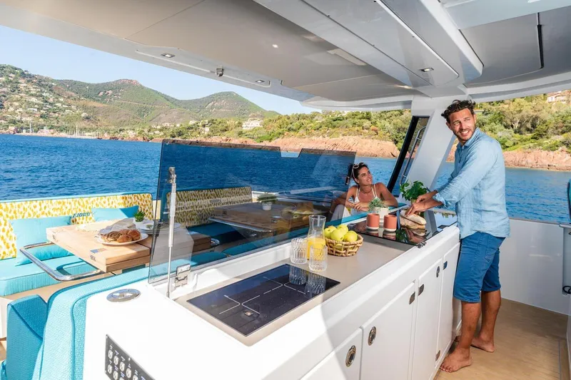  Yacht Photos Pics 2026 Fjord 490 OPEN yacht with people enjoying the deck and scenic coastal view.