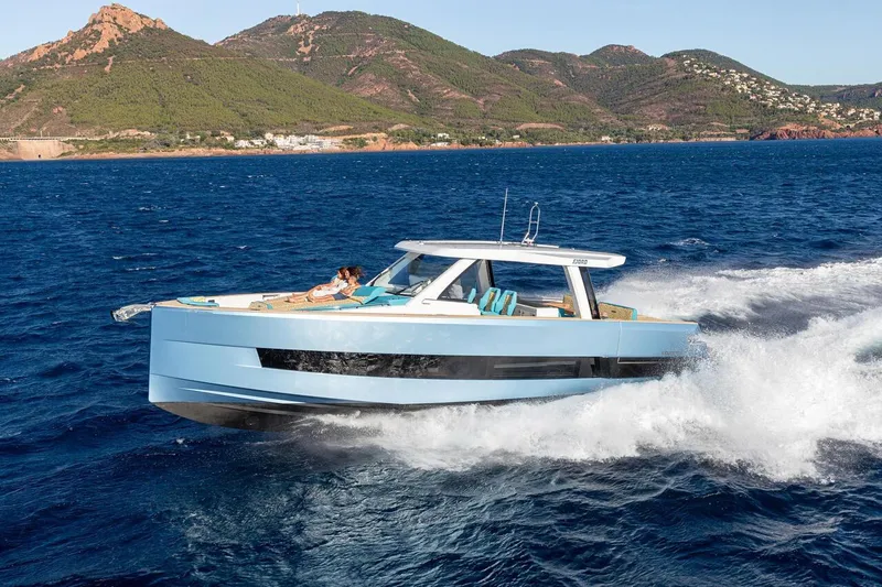  Yacht Photos Pics 2026 Fjord 490 OPEN cruising on blue ocean with scenic mountain backdrop.