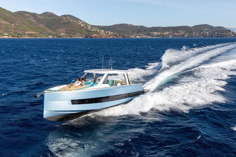  Yacht Photos Pics 2026 Fjord 490 OPEN yacht cruising on blue ocean with scenic coastal backdrop.