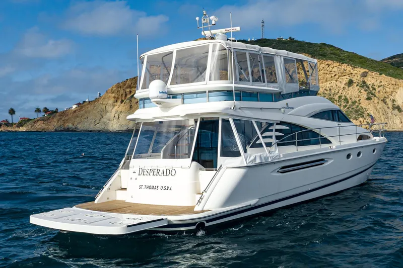 Desperado Yacht Photos Pics 2002 Fairline Squadron 58 yacht cruising near a scenic coastline.