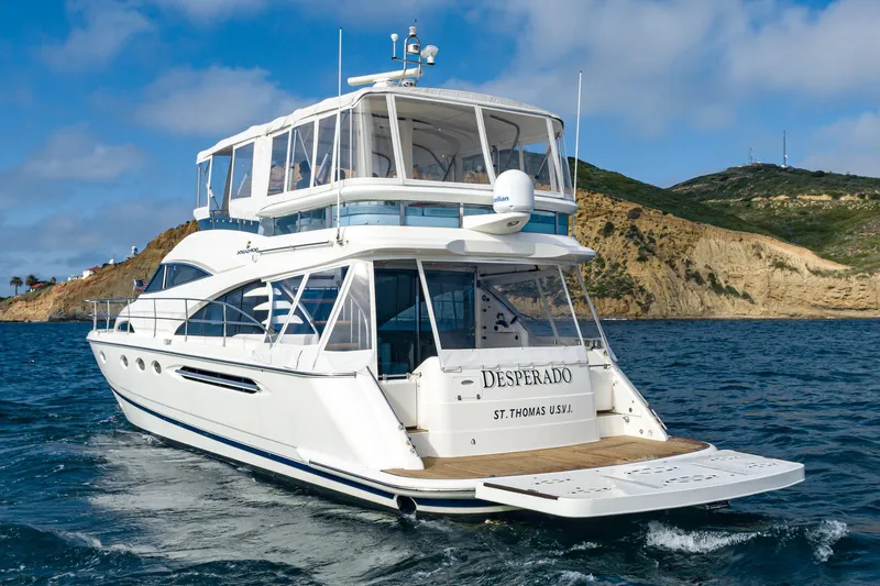 Desperado Yacht Photos Pics Luxury 2002 Fairline Squadron 58 yacht cruising near scenic coastline.