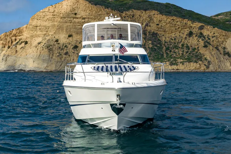 Desperado Yacht Photos Pics 2002 Fairline Squadron 58 yacht cruising near rocky coastline.