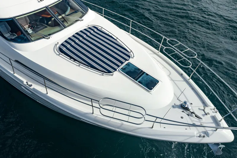 Desperado Yacht Photos Pics 2002 Fairline Squadron 58 yacht with striped sunpad, cruising on open water.