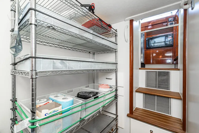 Desperado Yacht Photos Pics Storage area in 2002 Fairline Squadron 58 yacht with metal shelves and wooden steps.