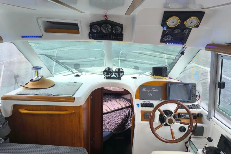  Yacht Photos Pics Interior of 2009 Jeanneau Merry Fischer 925 boat with navigation instruments and steering wheel.