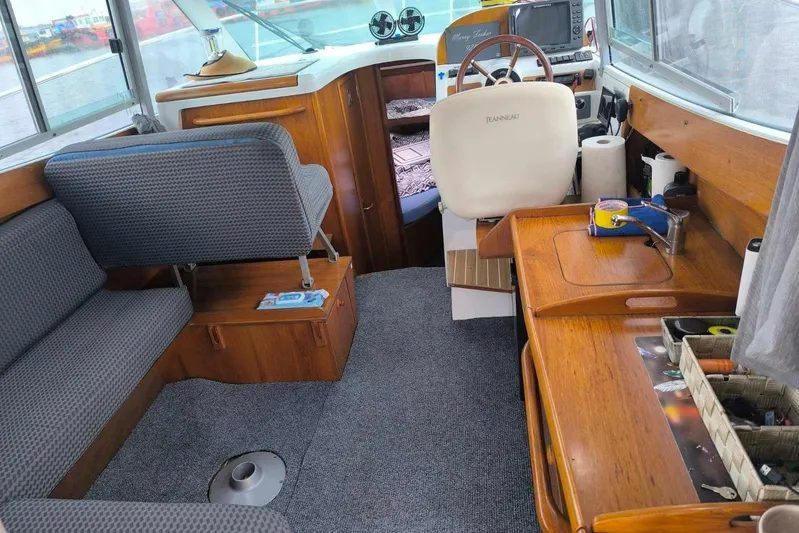  Yacht Photos Pics Interior of 2009 Jeanneau Merry Fischer 925 boat with seating and helm station.