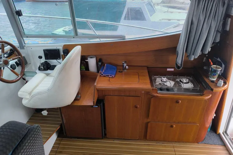  Yacht Photos Pics Interior of 2009 Jeanneau Merry Fischer 925 boat with helm and kitchenette.